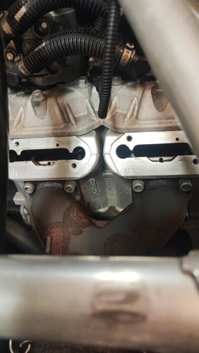 Motorblock med synliga kablar och rör, delvis isärtaget för rengöring och underhåll. Fokus på komponenter för handtagsvärme.