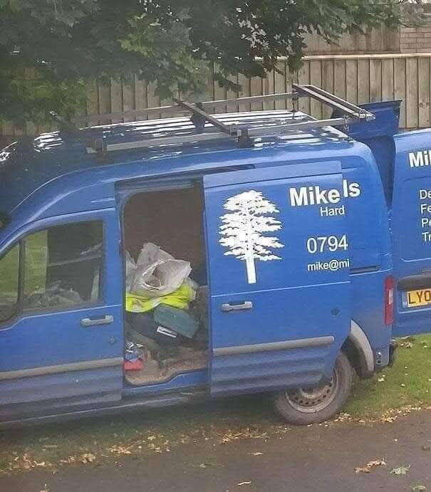 Blå skåpbil med namnet "Mike" på sidan, dörren öppen och verktyg samt material synliga inuti.