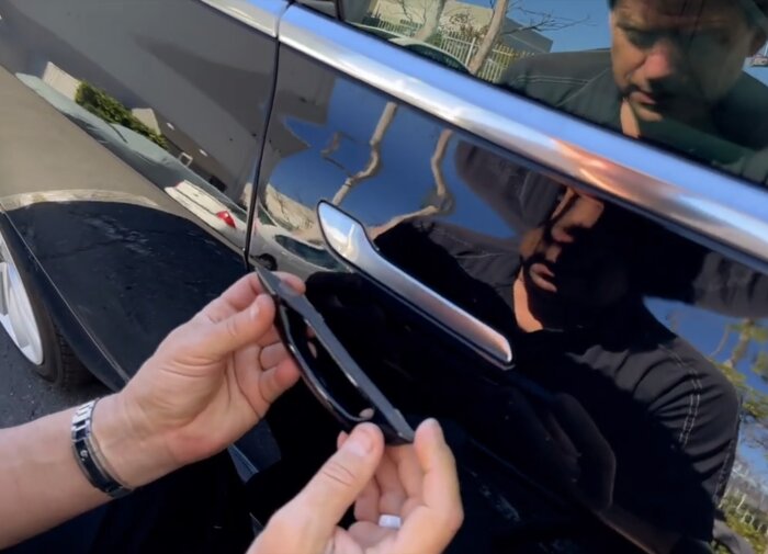 Dörrhandtag till en Tesla fästs med dubbelhäftande tejp.