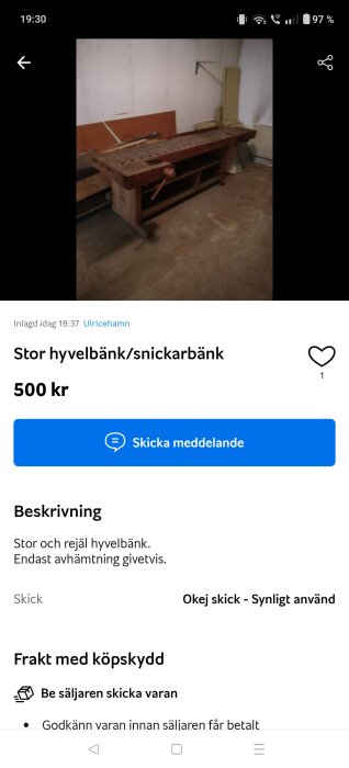 Stor, robust hyvelbänk i trä med tving, placerad i ett verkstadsrum. Hyvelbänken ser använd ut.