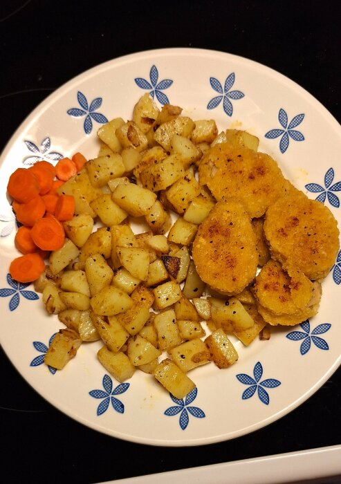 Tallrik med vegonuggets, stekt potatis, lök och morötter.