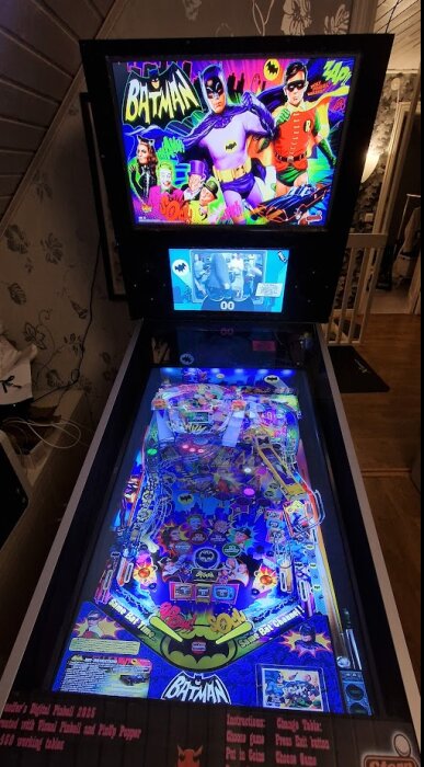 Hemgjord pinballmaskin med Batman-tema, med upplyst spelplan och skärm som visar grafiska detaljer och färgglada dekaler för ett retro-inspirerat spel.