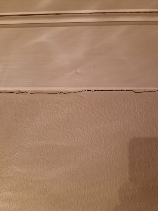 Sprickor i vävtak nära taklist i ett äldre trähus.