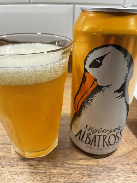 Ett glas gyllene öl bredvid en Stigbergets Albatross-burk på ett köksbord.