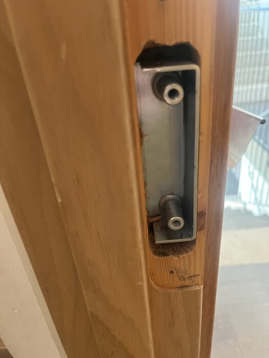 Dörrkarm med borrhål och metallbeslag som del av renoveringsprojekt.
