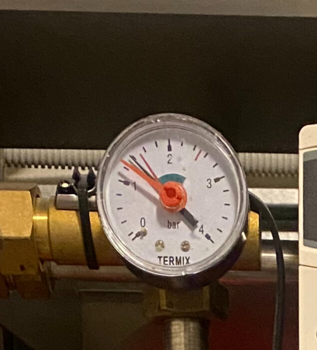 Tryckmätare på en Termix-enhet visar just nu ett tryck på cirka 1,6 bar med svarta och röda markeringar på skalan.