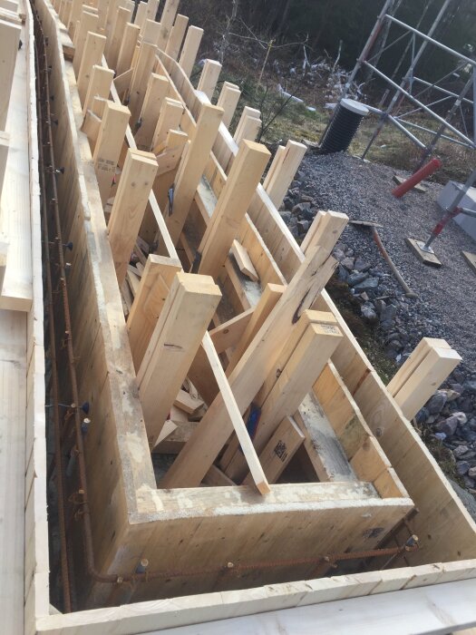 Formkonstruktion av trä 21x95 mm för gjutning på byggarbetsplats, med stag för stabilisering och armeringsjärn.