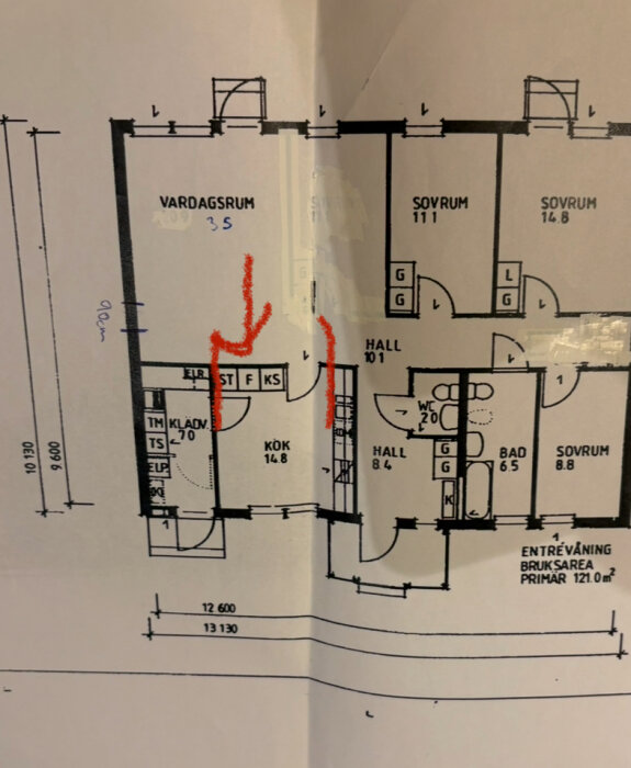 Planlösning av ett hus med markerad röd sektion för planerad väggnedrivning mellan kök och vardagsrum.