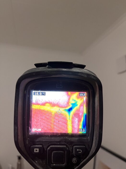 Termografikamera visar temperaturskillnader i husets hörn, med blå nyans, vilket kan indikera dålig isolering eller mögelproblem.