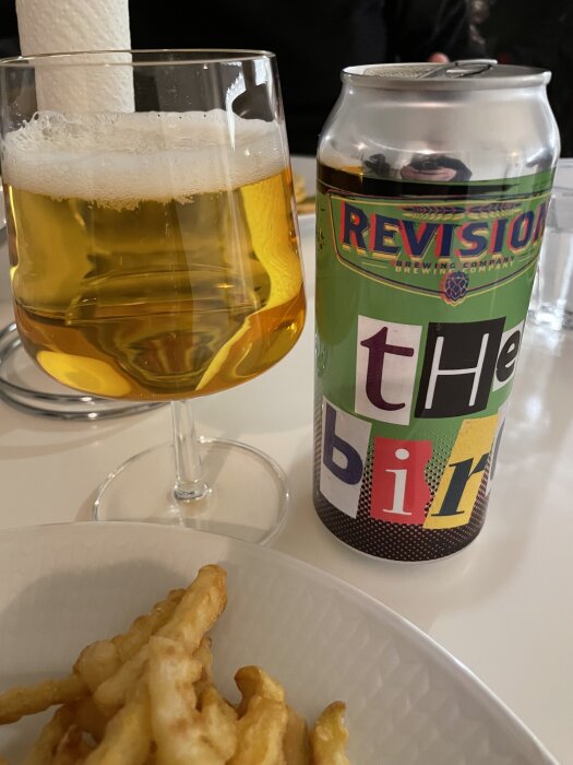 Ölglas och burk från Revision Brewing med franskfries på tallrik, del av inlägg om "hamburgarfredag".