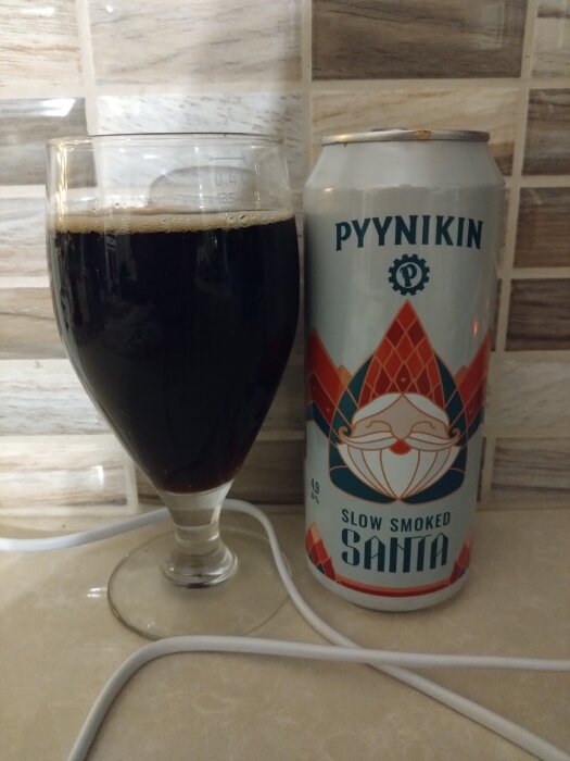 Ett glas mörk dryck bredvid en burk märkt "Pyynikin Slow Smoked Santa".