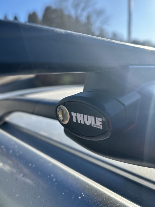 Takräcke med Thule-emblem och skruvhål, solbelyst bakgrund.