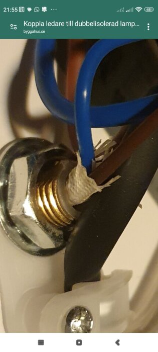 Ledningar med extra isolerstrumpa anslutna till en skruvkoppling, visar dubbelisolering i en lampinstallation.