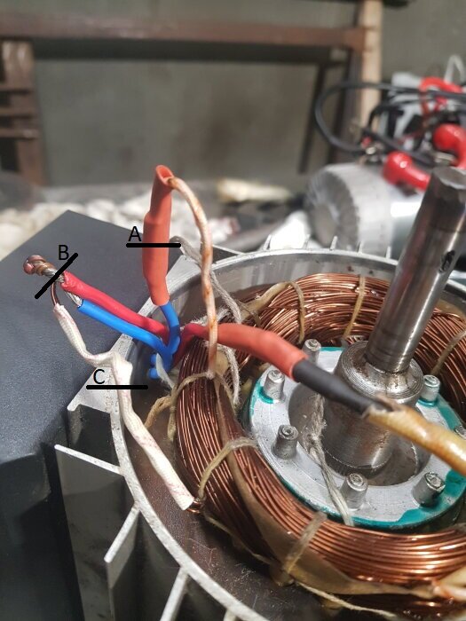 Motor med tre kabelanslutningar markerade A, B och C vid lindningar, visar olika skarv- och isoleringspunkter under modifiering.