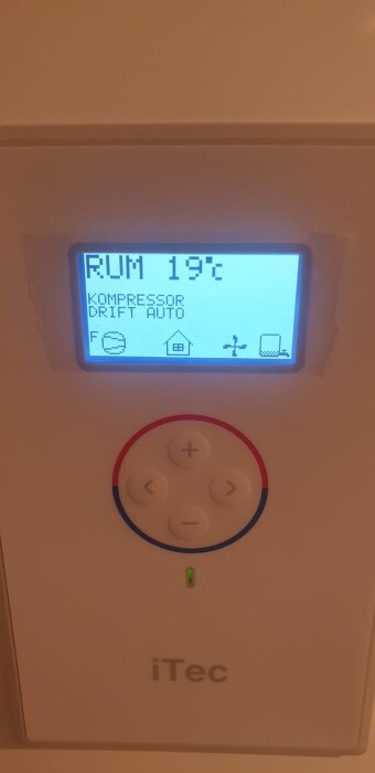 Display på värmepumpen Thermia iTec Eco Compact visar 19°C, med knappar under. Text: "KOMPRESSOR DRIFT AUTO".