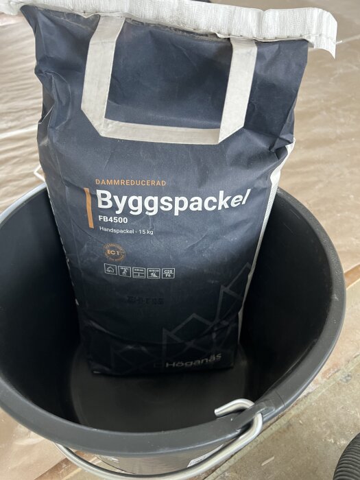 Påsen med Byggspackel står i en hink, redo att användas för golvutjämning enligt inläggsförfattarens projektfråga.