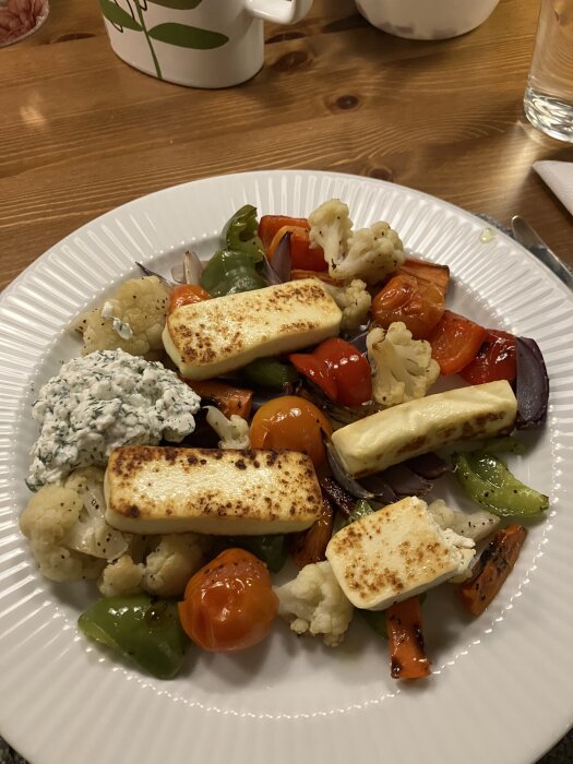 Tallrik med rostade grönsaker, paneer och dillkeso. Innehåller morötter, blomkål, paprika och tomater, toppat med balsamico.