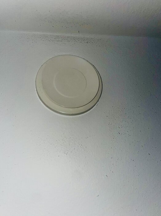 Ventilationsuttag med mögelliknande fläckar på väggen i en bostadsrätt.