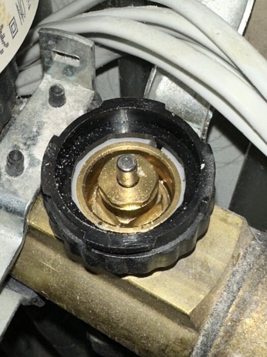 Närbild av en trasig ventil på ett golvvärmesystem från LK-system, där piggen verkar ha fastnat i stängt läge.