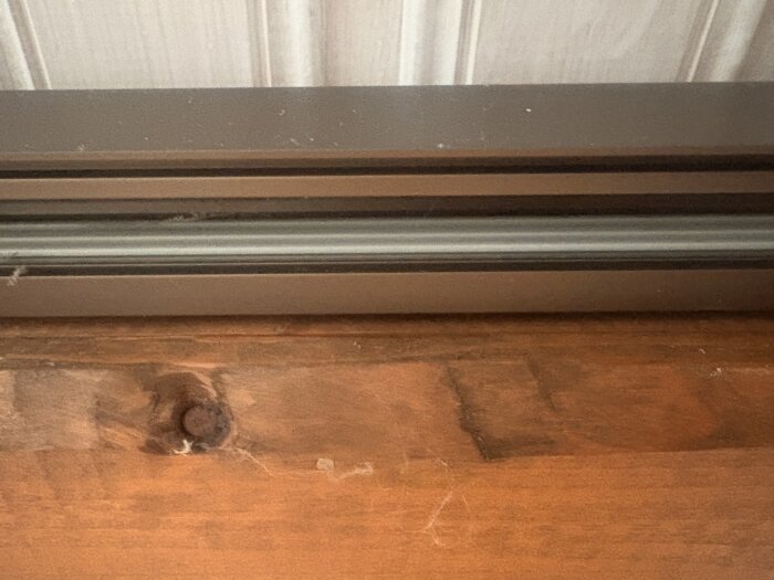 Brun belysningsskena med ledningar i taket på en villa, sett från sidan.