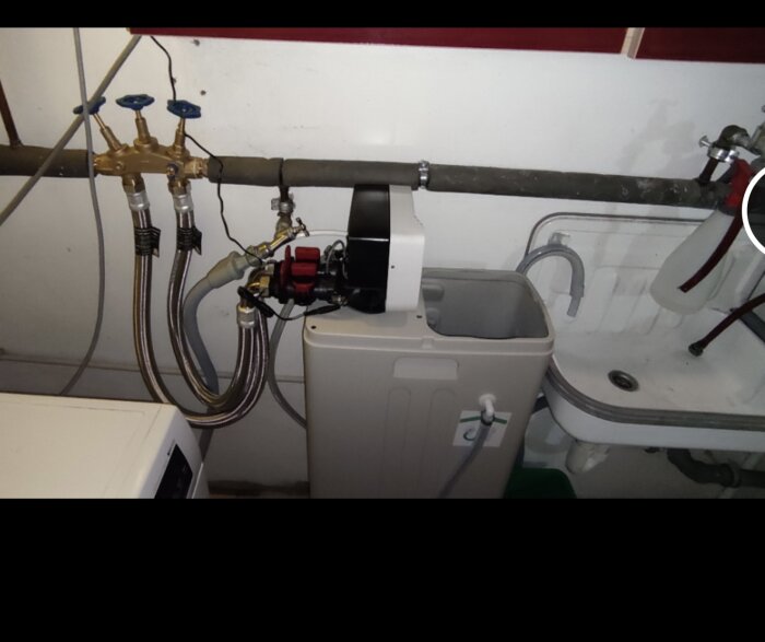 Installation av ett vattenfilteraggregat och rörledningar i ett tvättrum.