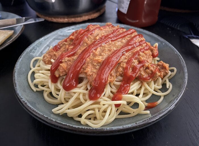 Spaghetti med tacofärsbaserad köttfärssås, dekorerad med ketchup.