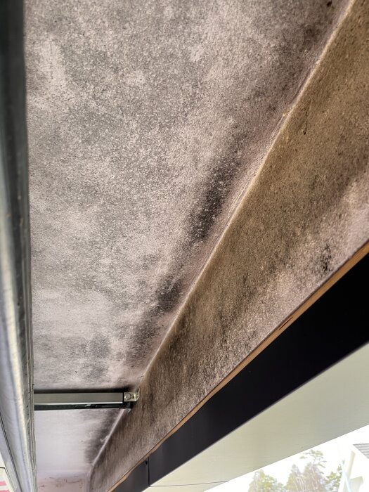 Grov yta av blåbetongvägg i ett garage med tecken på smuts eller mögel.