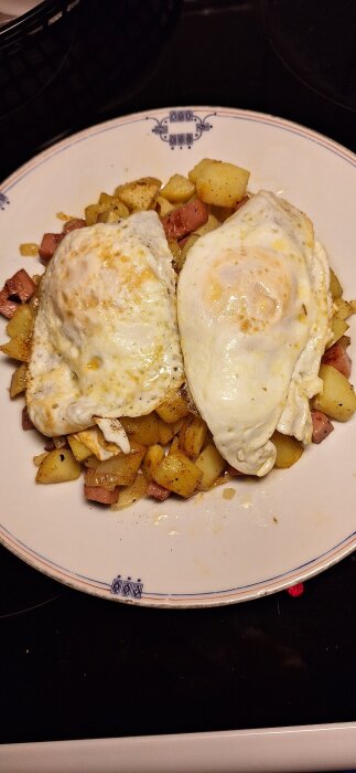 Pyttipanna med stekta ägg på en tallrik.