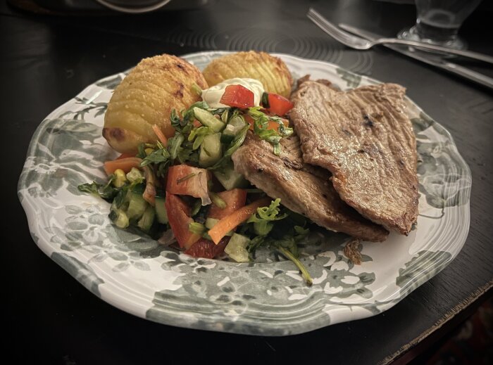 Tallrik med lövbiff, sallad, hasselbackspotatis och sås.
