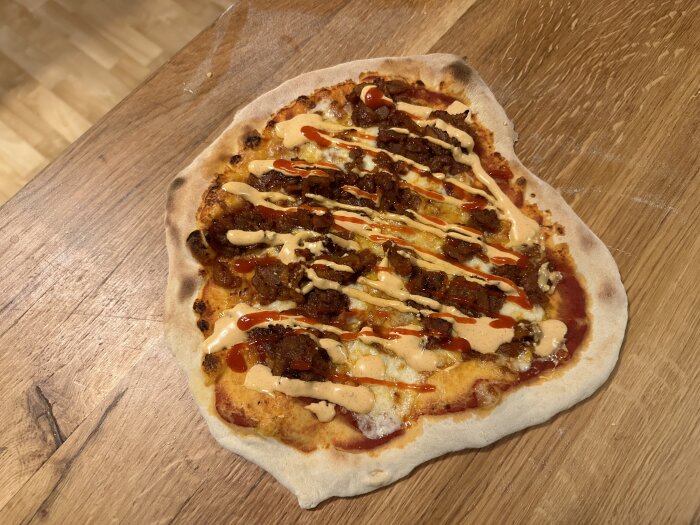 Hemlagad pizza med överjäst deg, tomatsås, blandade ostar, bao buns-fyllning och kebabsås, gräddad på ouppvärmt stål och serverad på träbord.