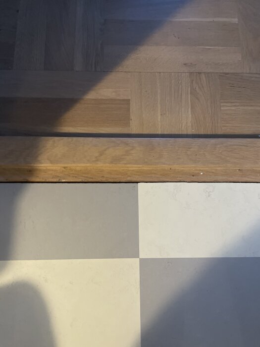 Skarv mellan tröskel och Forbo Marmoleum Click-golv i färgerna moon och orbit, med synlig nivåskillnad.