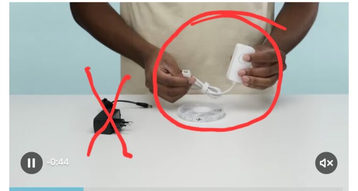 Person håller en vit komponent och kabel som är inringad, med en svart komponent överkryssad bredvid.