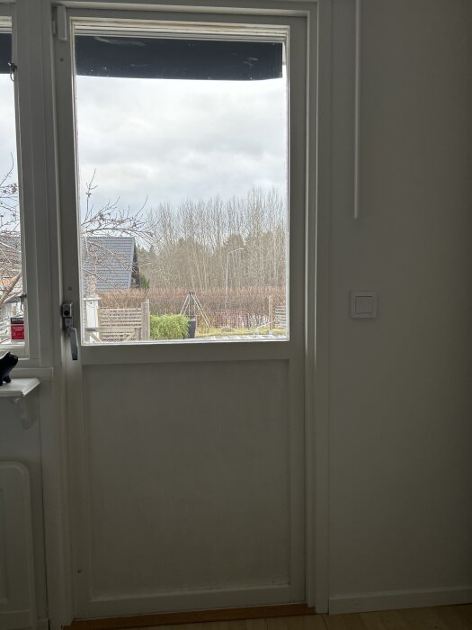 Altandörr från 1975 med glasruta, öppning mot trädgård. Dörren ska bytas mot en fönsterdörr från Elitfönster.