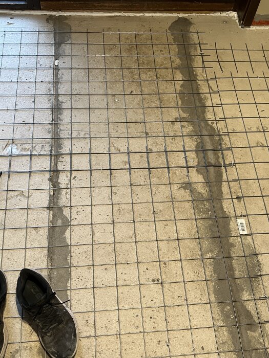 Golv med gallerarmering över betong, samt ett par svarta skor i bilden, från byggforumstråd om tunnaste materialet från Jemofix.