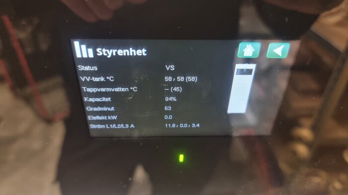 Avläst temperatur och status på en värmeanläggnings styrpanel, högsta VV-temp 58°C, tappvarmvatten ej aktiv, kapacitet 94%, effekt 0 kW.