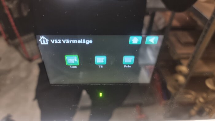 Digital skärm som visar värmeläge för VS2 med alternativ för Auto, Till och Från, sannolikt kopplat till värmesystem.