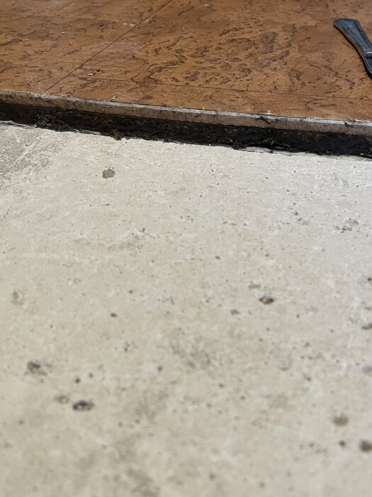 Närbild av ett betongblock under ett brunt golv, i diskussion om det kan vara blåbetong.