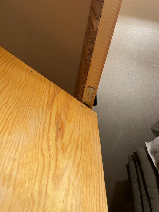 En trädörr monterad med vridgångjärn i en dörrkarm, del av ett byggprojekt för att skapa en stabil och stilren konstruktion.