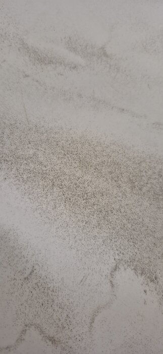 Mörkare sediment eller avlagringar på botten av ett badkar efter att ha tömt missfärgat vatten från en nyborrad brunn.