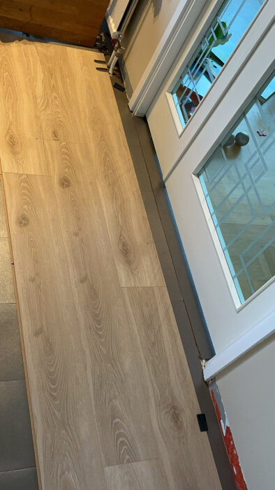 Laminatgolv med skarvar nära varandra vid dörröppning, fråga om förskjutning på minst 35 cm.