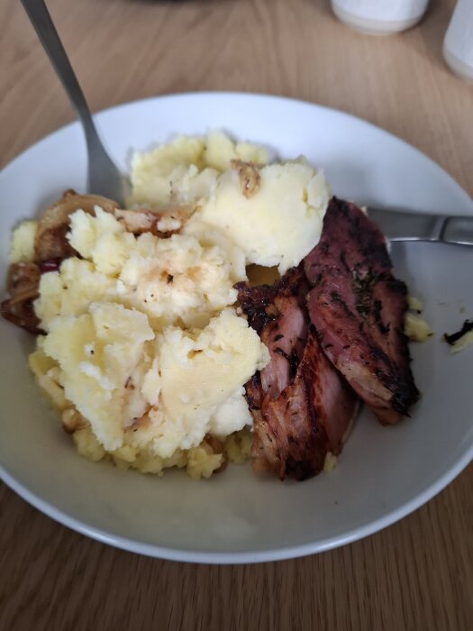 Tallrik med mosad potatis och kött, serverad med sked, rester från gårdagens måltid.