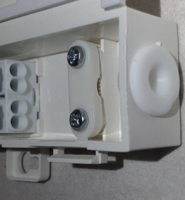 Närbild av en dragavlastning i en elektrisk kopplingsdosa med skruvar, använd för att fästa kabeln.