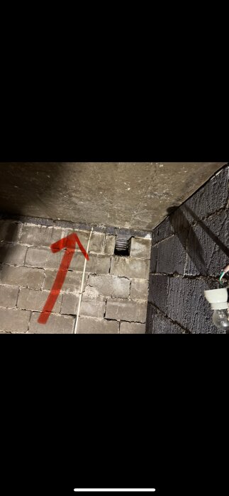 Betongvägg med yttre lager blåbetongblock i suterränghus; röd pil pekar uppåt mot bjälklagets placering.