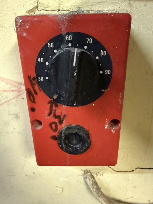 Rött reglage för elpatron med temperaturskala 30-90 grader, gummiknapp nedanför. I behov av återställning för fungerande värmesystem.