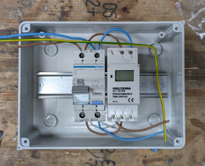 Programmerbart tidur och strömbrytare i en kopplingslåda med elkablar anslutna för installation av en pump.