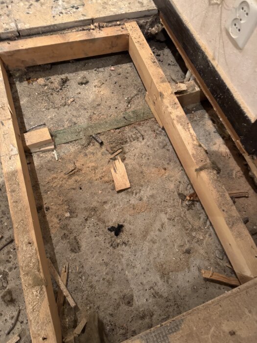 Övervåning under renovering, synliga reglar och ojämn betongyta.