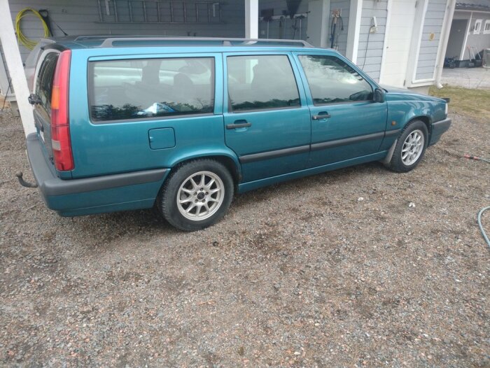 Grön bil, en Volvo kombi, står på en grusig uppfart framför en garageport. Bilen är nyligen behandlad med plastmedel.