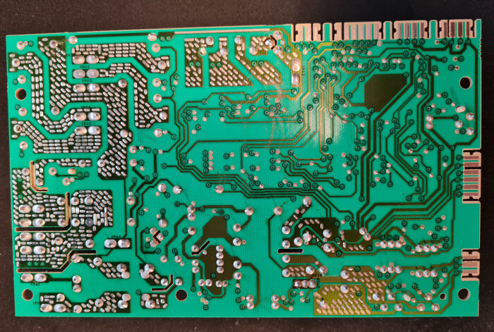 Undersidan av ett kretskort utan brända komponenter, men en dålig lödning visas.