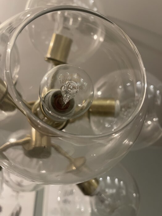 Närbild på en lampa med glasglober och flera E14-ljushållare.