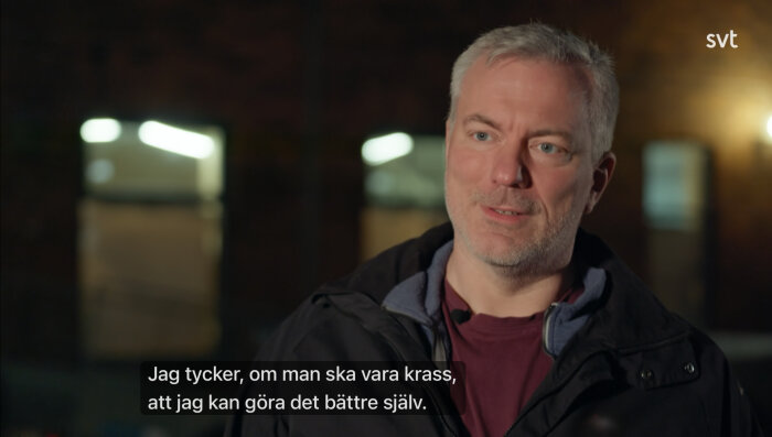 Man i jacka pratar, med texten: "Jag tycker, om man ska vara krass, att jag kan göra det bättre själv." på en mörk bakgrund med ljusögonblick.